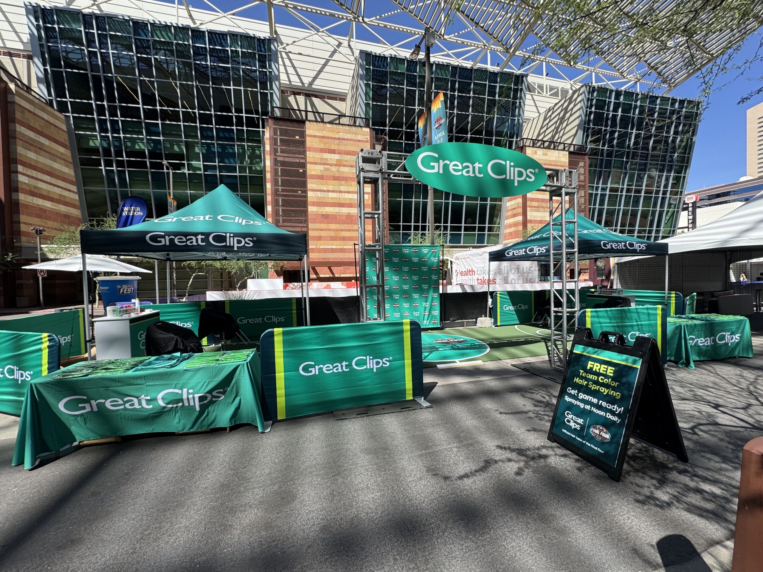 Great Clips branded booth at the Women’s Final Four featuring custom barricade signage and a large oval display sign produced by 3tree Marketing